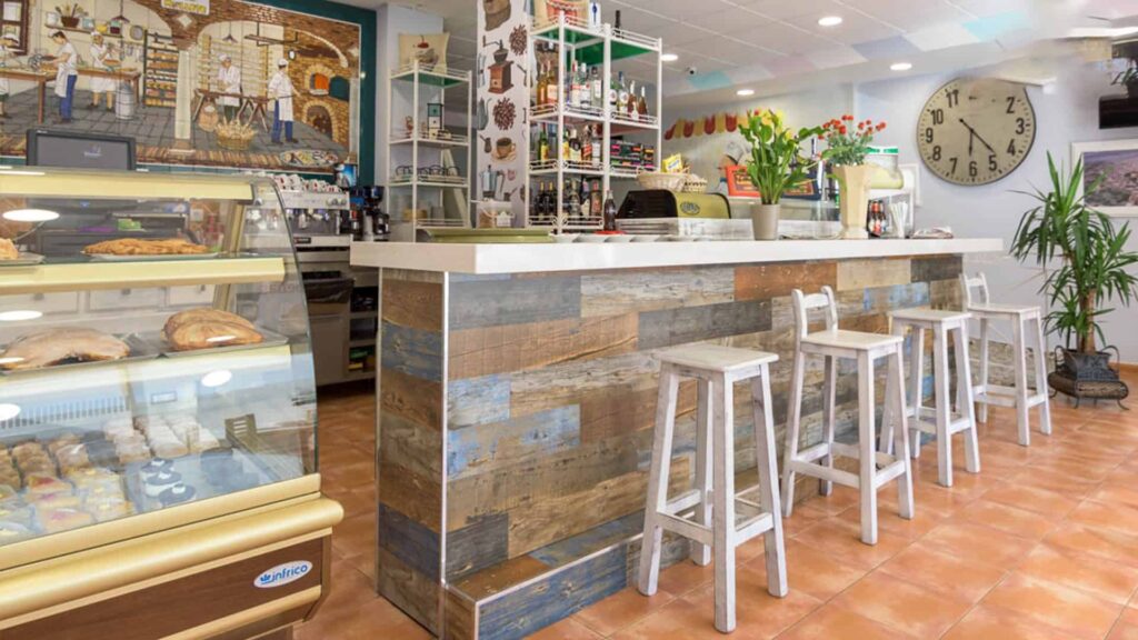 Vista global del interior de una cafetería con la barra en primer plano